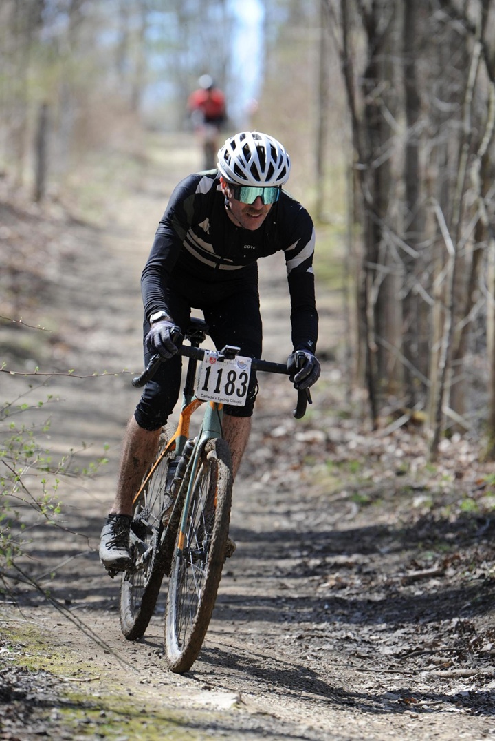 riding in the middle of a forest with a lone rider in the background